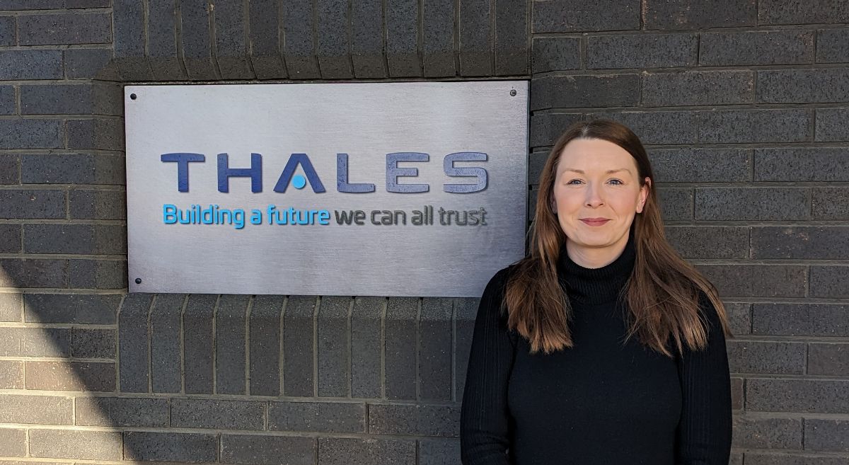 Sarah Hewitt standing beside metal sign